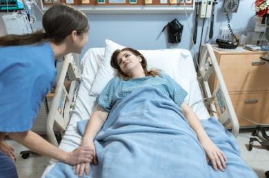 免费 躺在医院的床上的蓝色衬衫的女人 素材图片